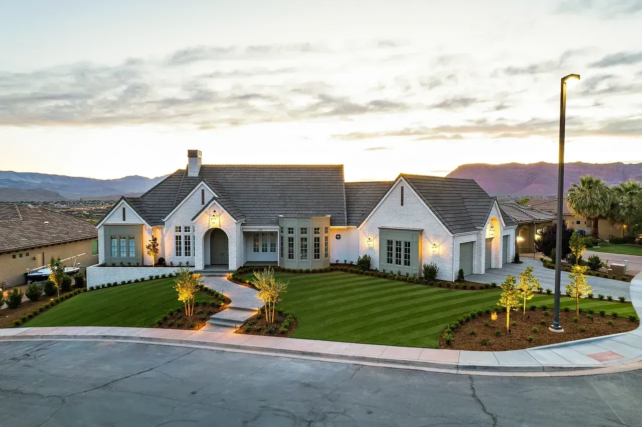 Luxury landscaped home with manicured lawn at dusk